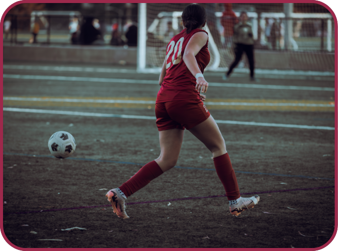 a girl running on a soccer field